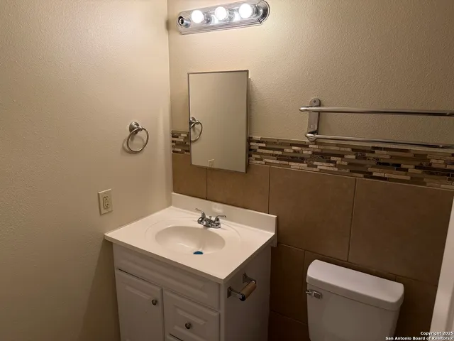 a bathroom with a sink toilet and mirror