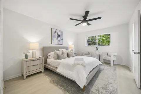 a bedroom with a bed and a large window
