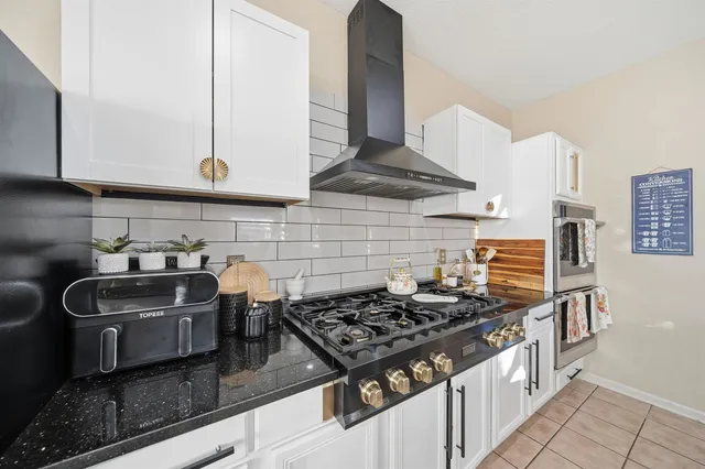 a kitchen with stainless steel appliances granite countertop a stove and a sink