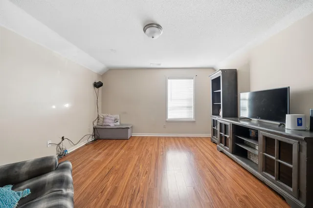 a view of a livingroom with wooden floor and furniture