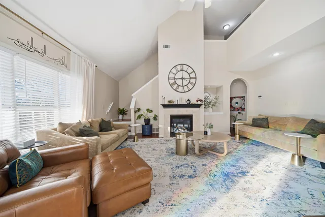 a living room with furniture a fireplace and a large mirror