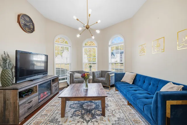 a living room with furniture a flat screen tv and a fireplace