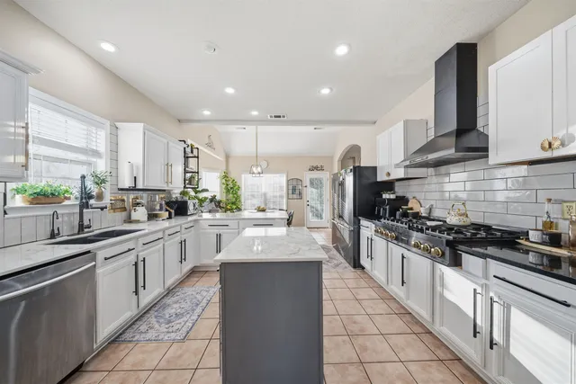 a large kitchen with stainless steel appliances granite countertop a sink and cabinets