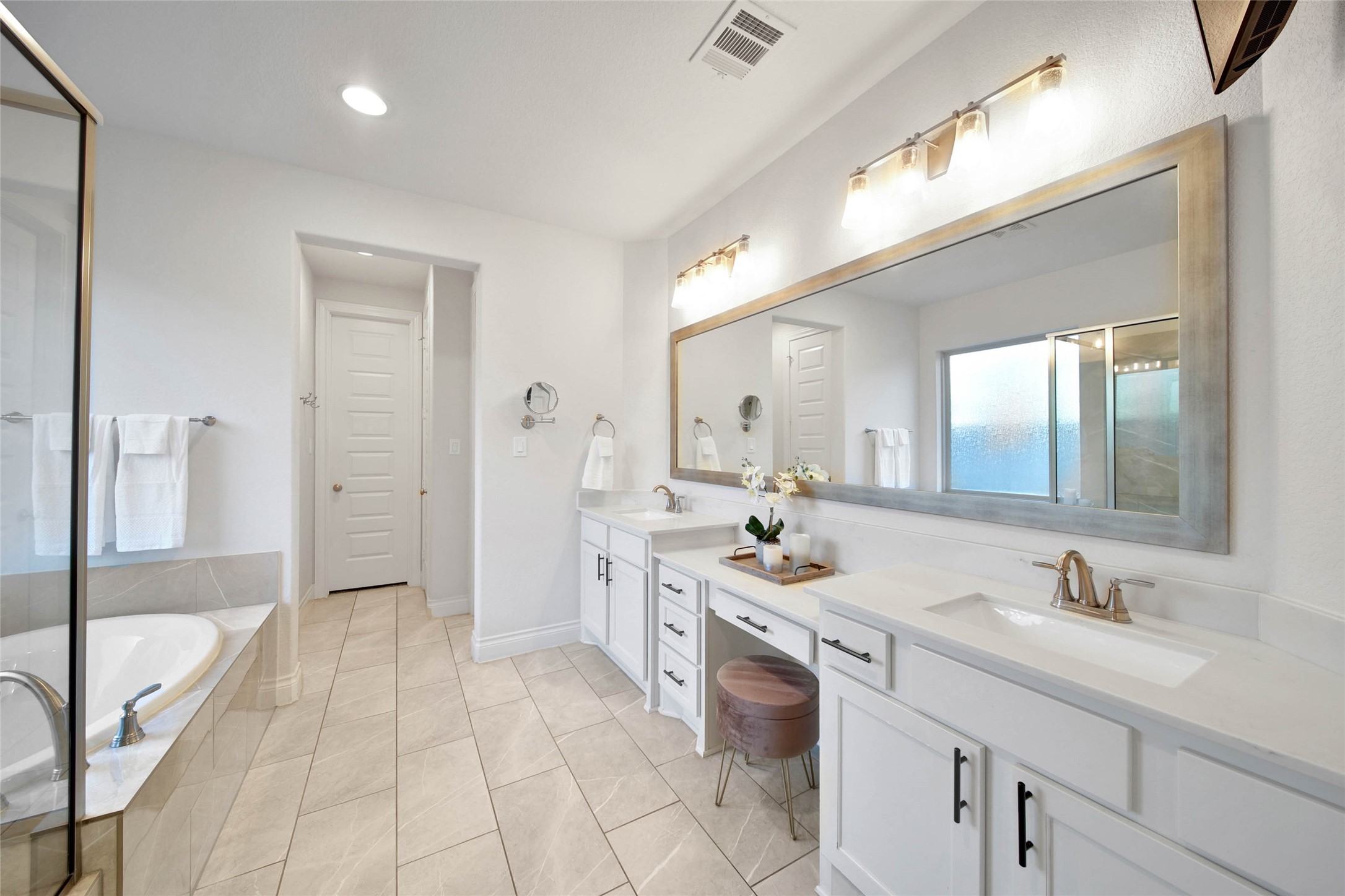28602 Mountain Timber Court Fulshear, TX 77441 - Photo 23 of 47 The primary bath features dual sinks, a sit-down vanity area, and dual walk in closets, offering plenty of space for two to get ready with ease. It’s designed for both functionality and comfort to start your day right.