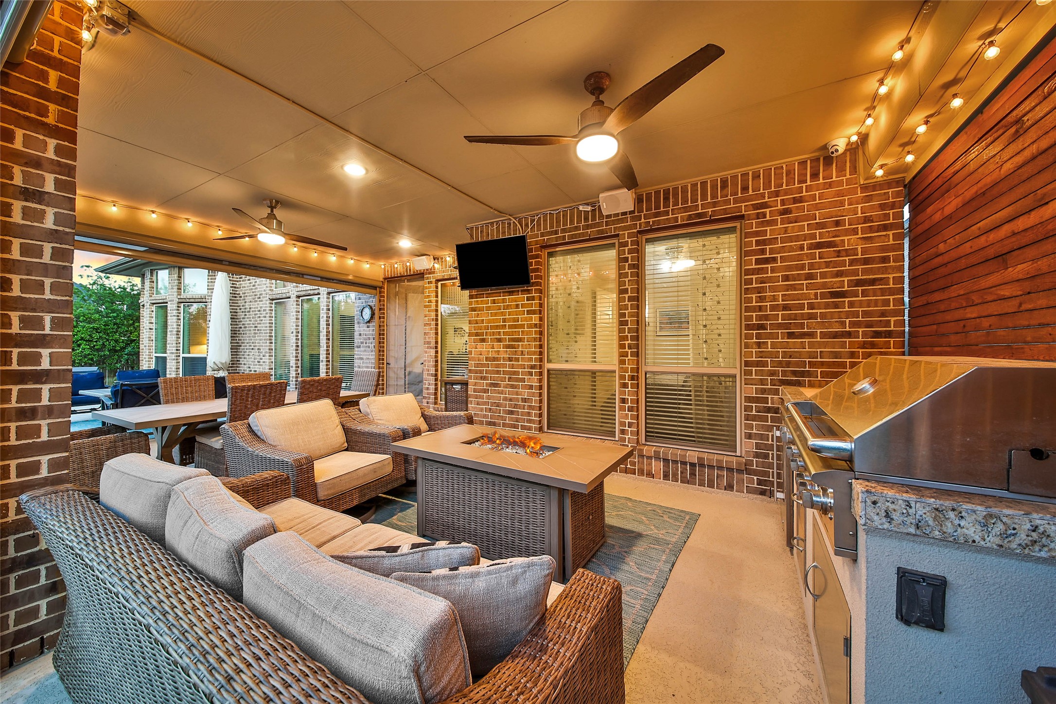 28602 Mountain Timber Court Fulshear, TX 77441 - Photo 38 of 47 Evening Ambiance! The outdoor kitchen features a grill, two burners, and an outdoor refrigerator, making it effortless to prepare meals and dine al fresco.