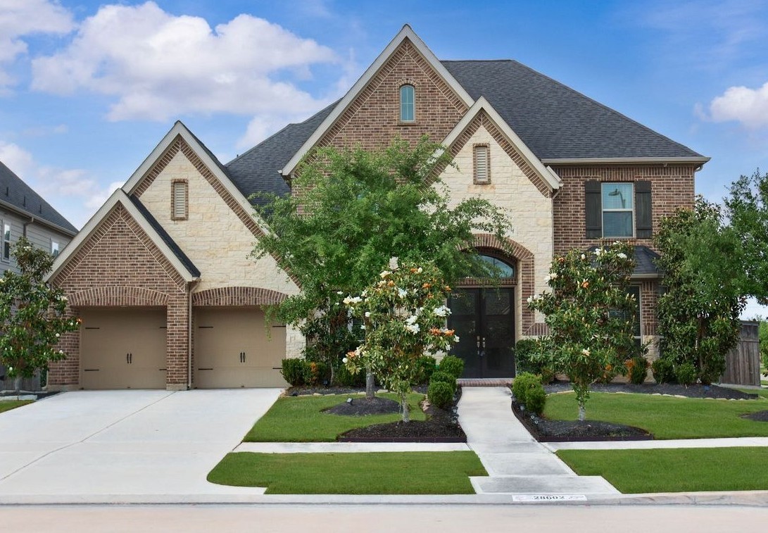 28602 Mountain Timber Court Fulshear, TX 77441 - Photo 8 of 47 Great curb appeal with a beautiful blend of brick and stone creating an inviting exterior. Mature landscaping accents the front yard and welcomes guests.