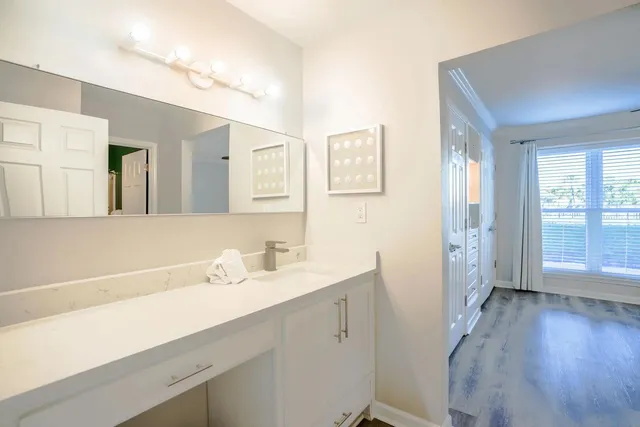 a bathroom with a sink a mirror a vanity and a shower
