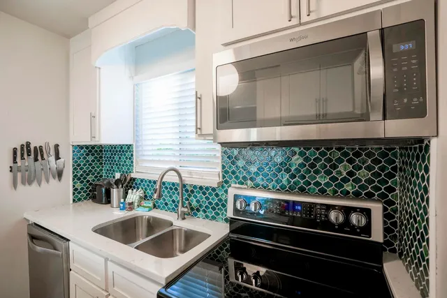 a kitchen with a sink and a stove top oven