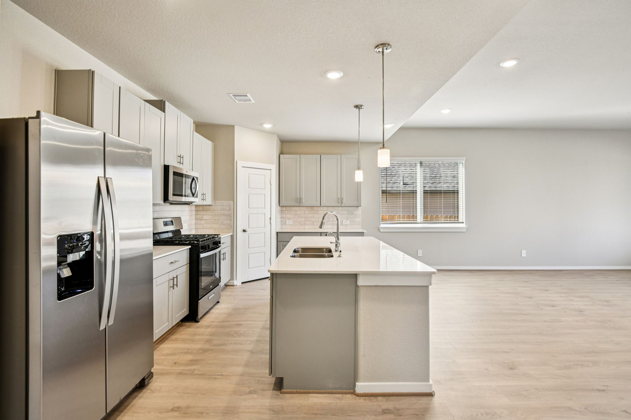 17892 Stone Terrace Montgomery, TX 77316 - Photo 18 of 49 a kitchen with kitchen island stainless steel appliances a sink stove and refrigerator