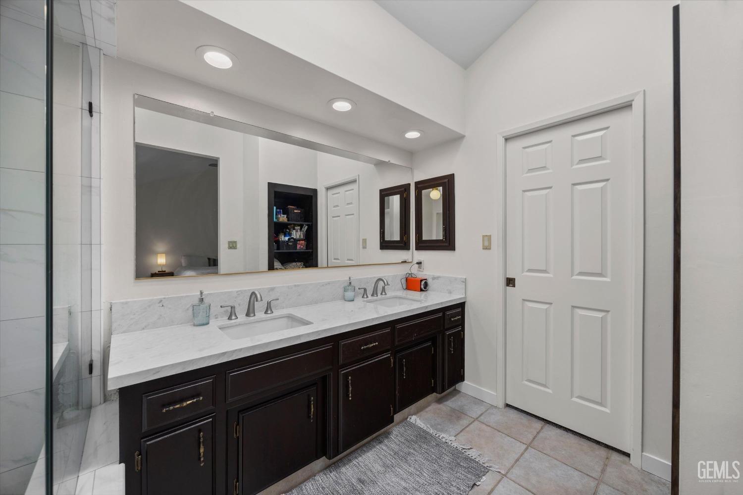 Undisclosed Address Bakersfield, CA 93311 - Photo 23 of 34 a bathroom with a double vanity sink and mirror