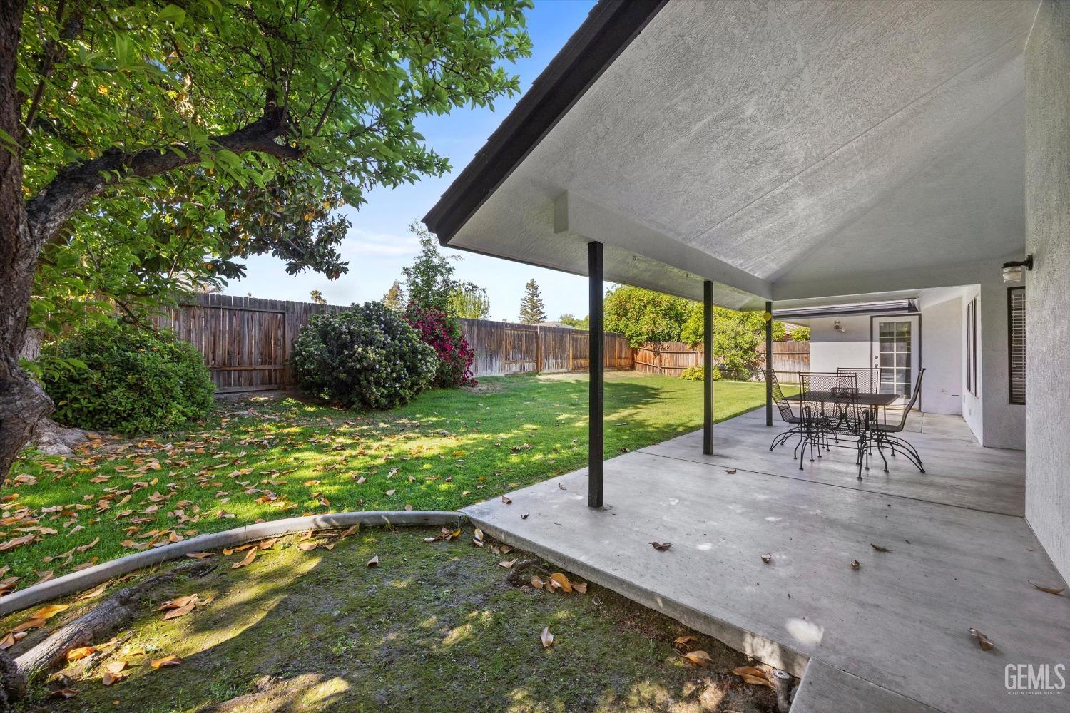 Undisclosed Address Bakersfield, CA 93311 - Photo 30 of 34 a view of a backyard with table and chairs under an umbrella