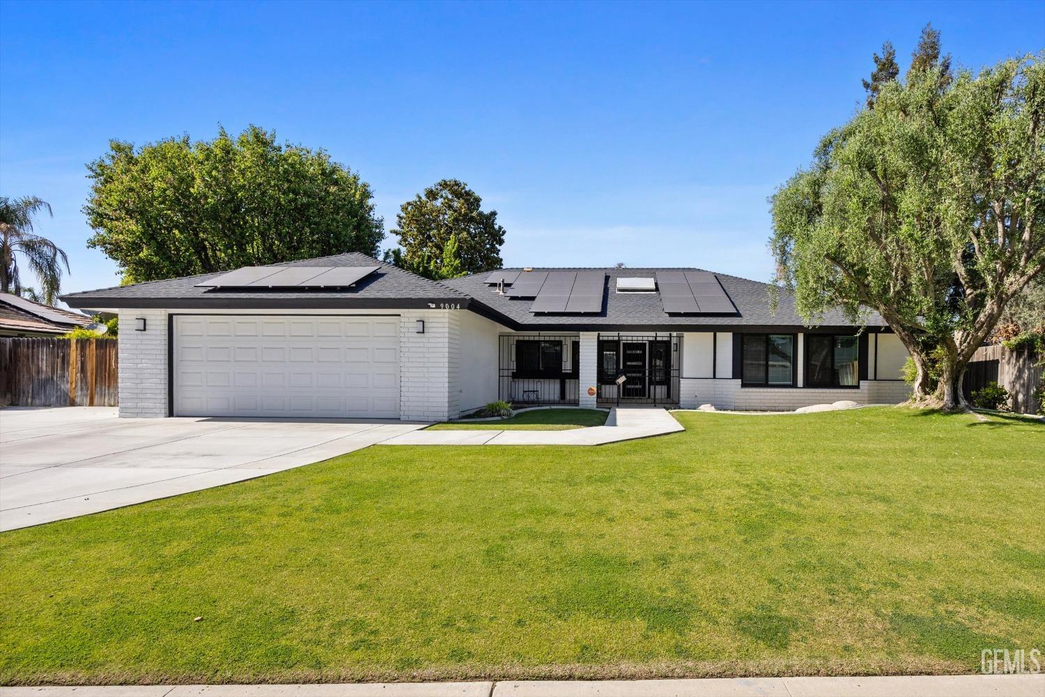 Undisclosed Address Bakersfield, CA 93311 - Photo 3 of 34 a front view of a house with a garden and trees