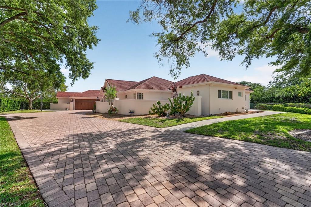 175 Palm River Boulevard Naples, FL 34110 - Photo 1 of 45 a front view of a house with a yard and garage