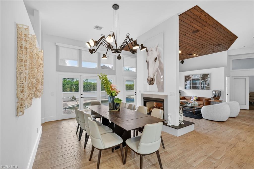 175 Palm River Boulevard Naples, FL 34110 - Photo 15 of 45 a view of a dining room with furniture a fireplace and wooden floor