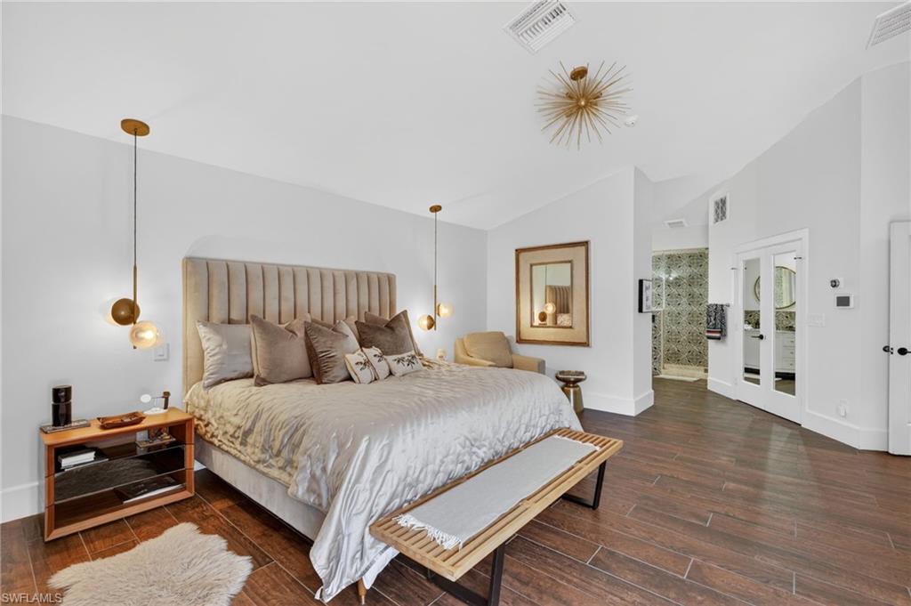 175 Palm River Boulevard Naples, FL 34110 - Photo 22 of 45 a bedroom with a bed and a chandelier