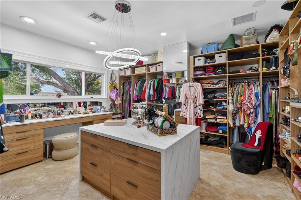 175 Palm River Boulevard Naples, FL 34110 - Photo 25 of 45 a view of walk in closet with clothes and shoes