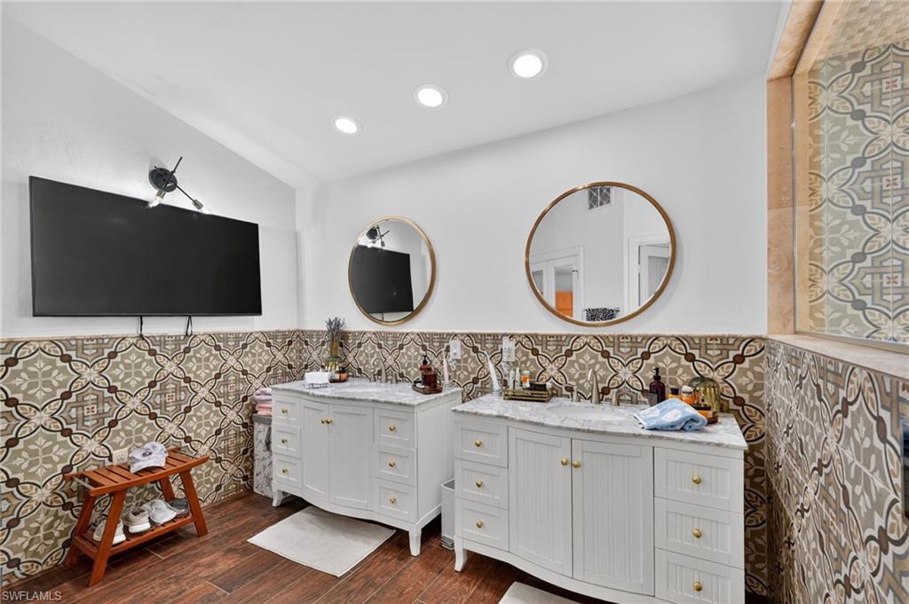 175 Palm River Boulevard Naples, FL 34110 - Photo 26 of 45 a bathroom with a double vanity sink and mirror