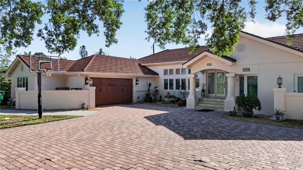 175 Palm River Boulevard Naples, FL 34110 - Photo 5 of 45 a front view of a house with a garden