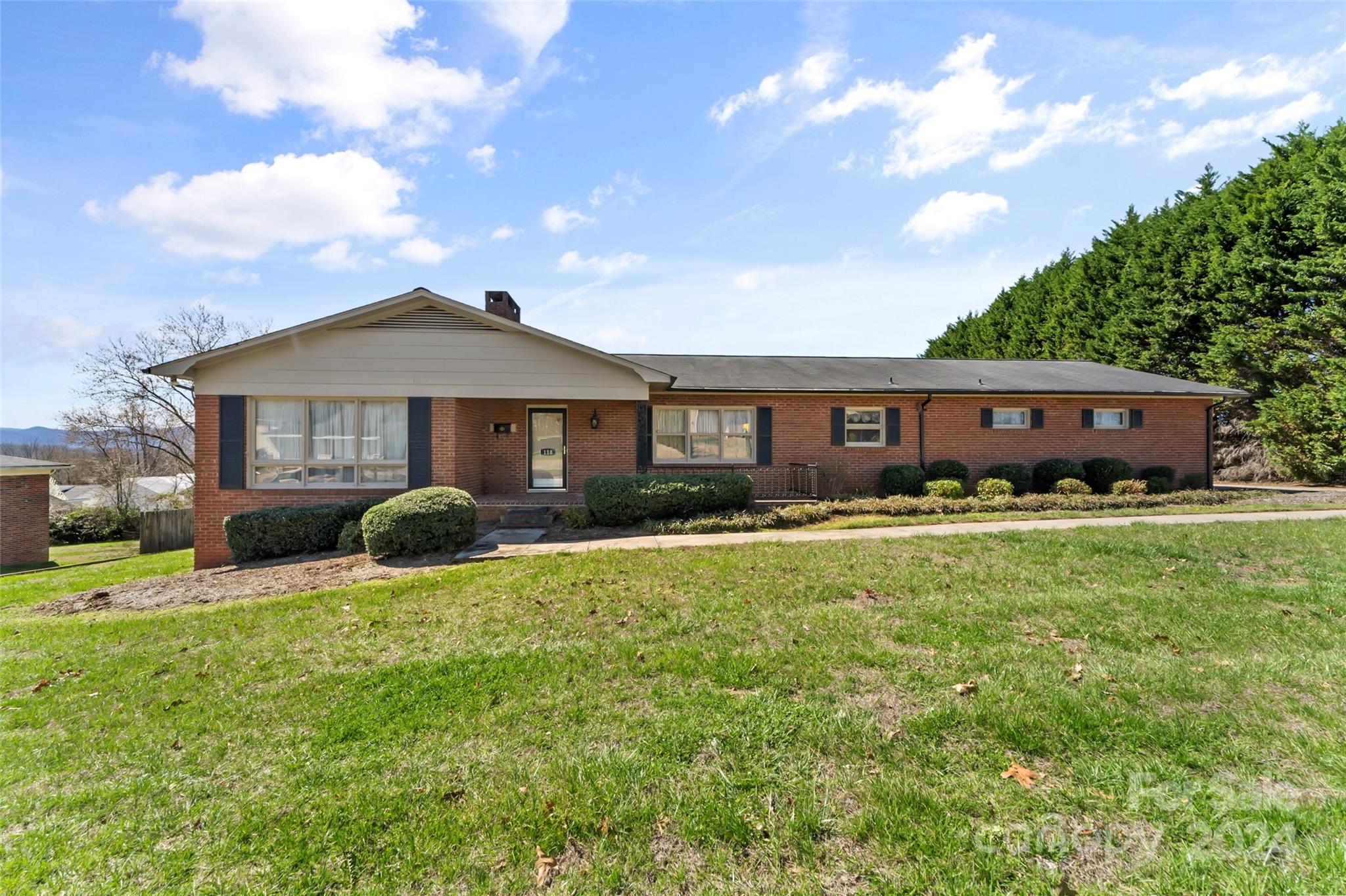 a view of a house with a yard and sitting area