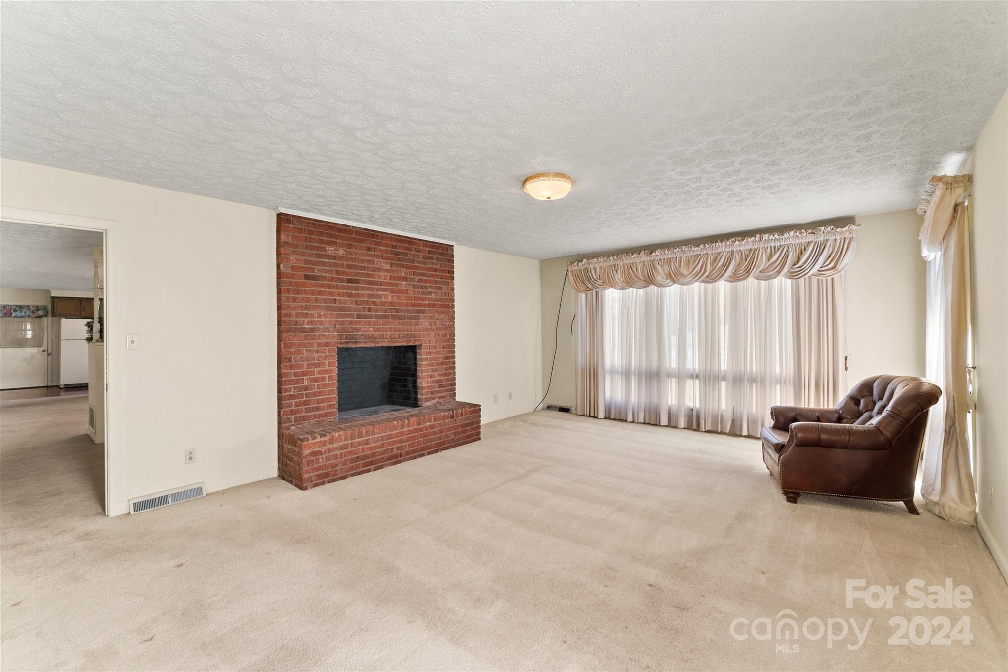 110 Stephens Drive Morganton, NC 28655 - Photo 11 of 29 a view of an empty room with a fireplace and a window