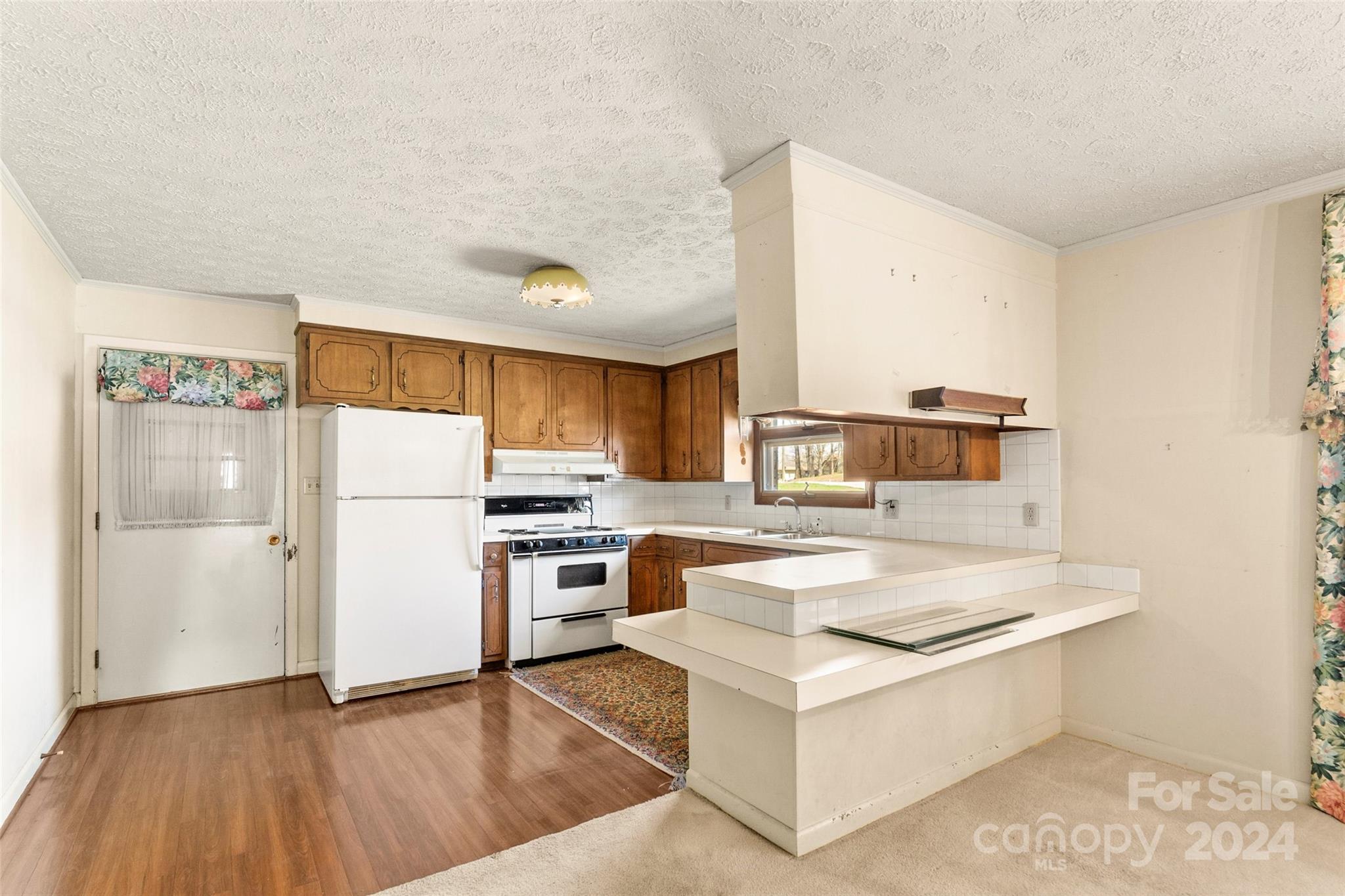 110 Stephens Drive Morganton, NC 28655 - Photo 7 of 29 a kitchen with a stove a refrigerator and white cabinets