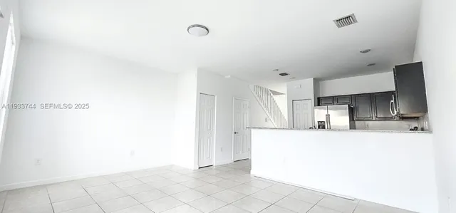 a large white kitchen with cabinets and a refrigerator