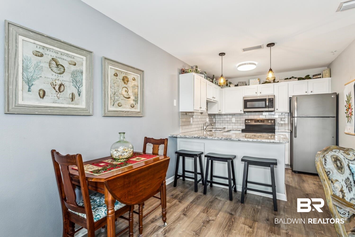 13551 Johnson Beach Road, Unit 112E Pensacola, FL 32507 - Photo 10 of 42 Kitchen featuring kitchen peninsula, stainless steel appliances, tasteful backsplash, hanging light fixtures, and white cabinets