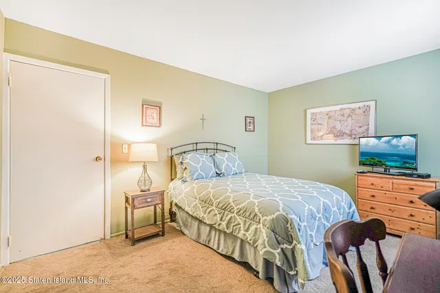 a bedroom with a bed and a lamp on the dresser