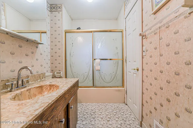 a bathroom with a granite countertop sink a mirror a vanity and a shower