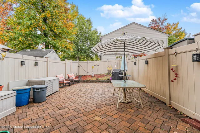 a view of a patio with table and chairs and wooden fence