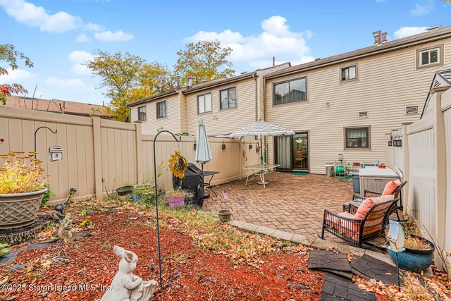 a backyard of a house with barbeque oven table and chairs