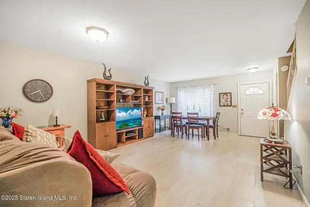 a living room with furniture a dining table and a large window