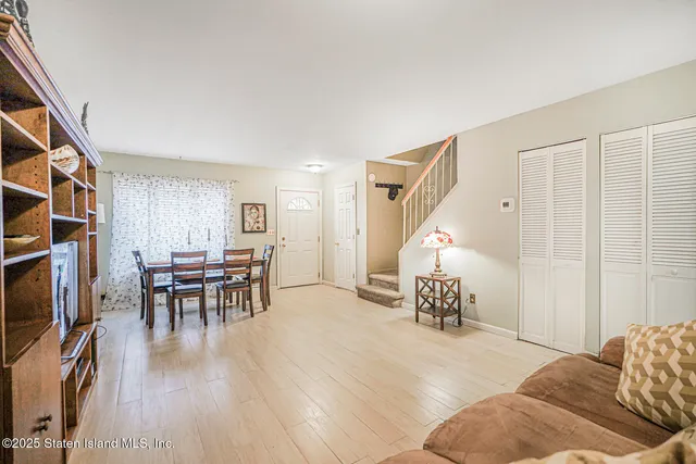 a living room with furniture and a dining table with wooden floor