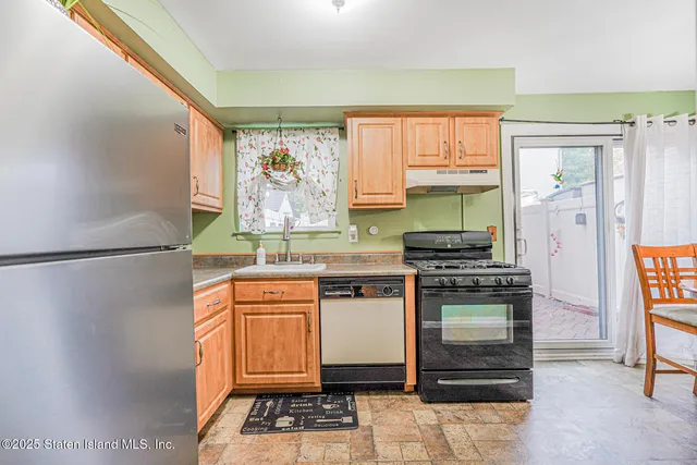 a kitchen with stainless steel appliances granite countertop a stove a sink and a refrigerator