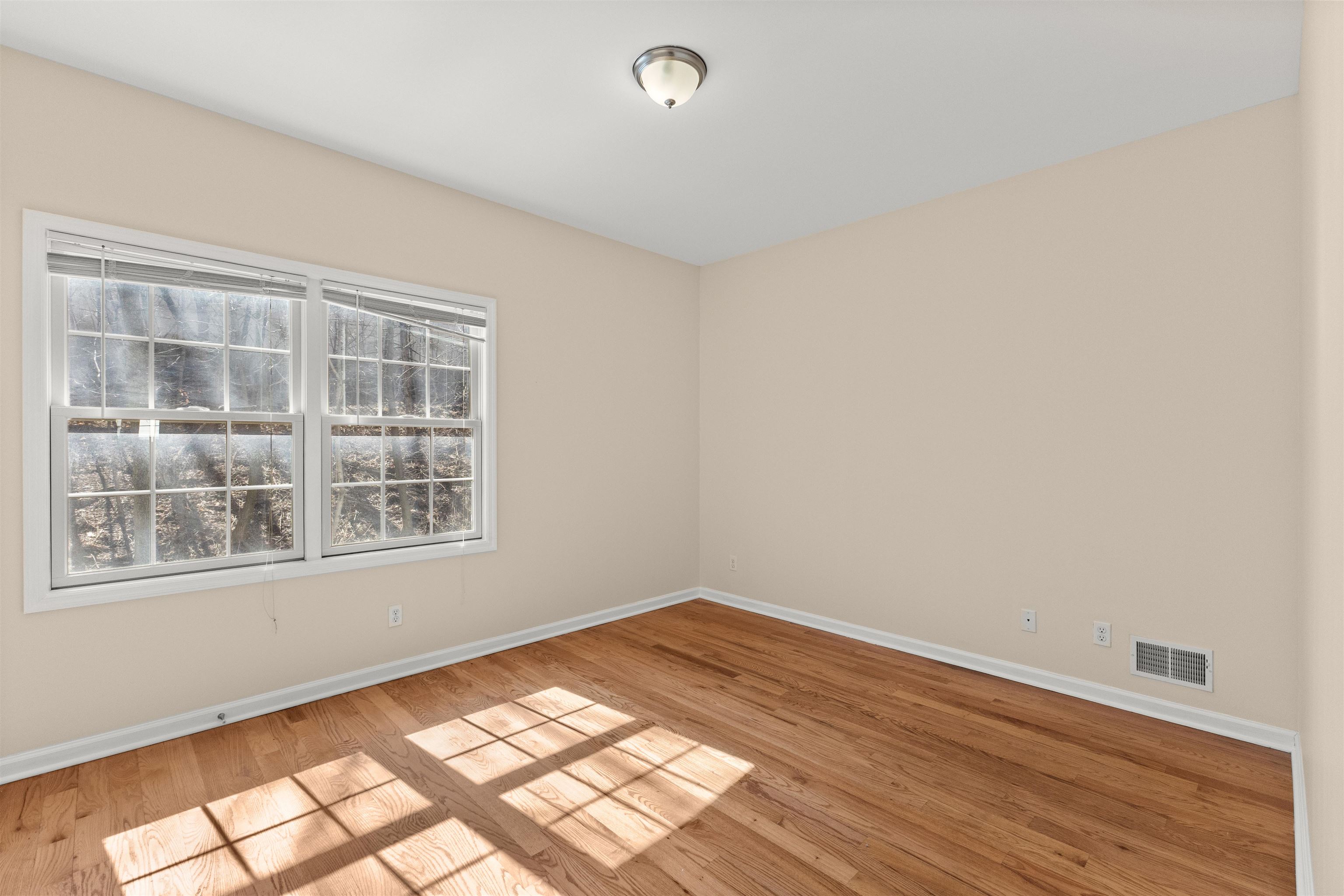 23 Reynolds Avenue, Unit 1 Harrison, NJ 07029 - Photo 14 of 23 a view of an empty room with wooden floor and a window