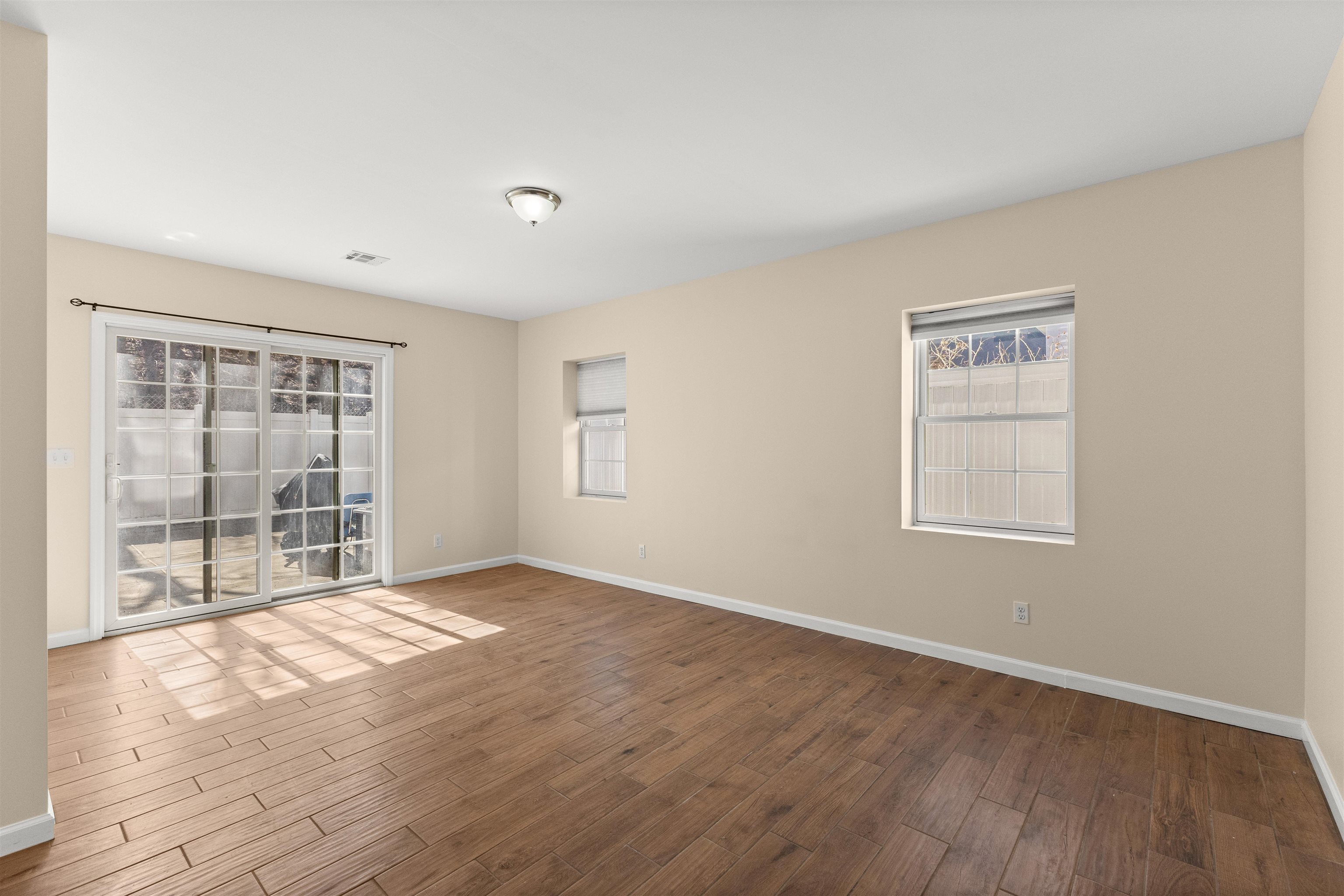 23 Reynolds Avenue, Unit 1 Harrison, NJ 07029 - Photo 19 of 23 a view of an empty room with wooden floor and a window
