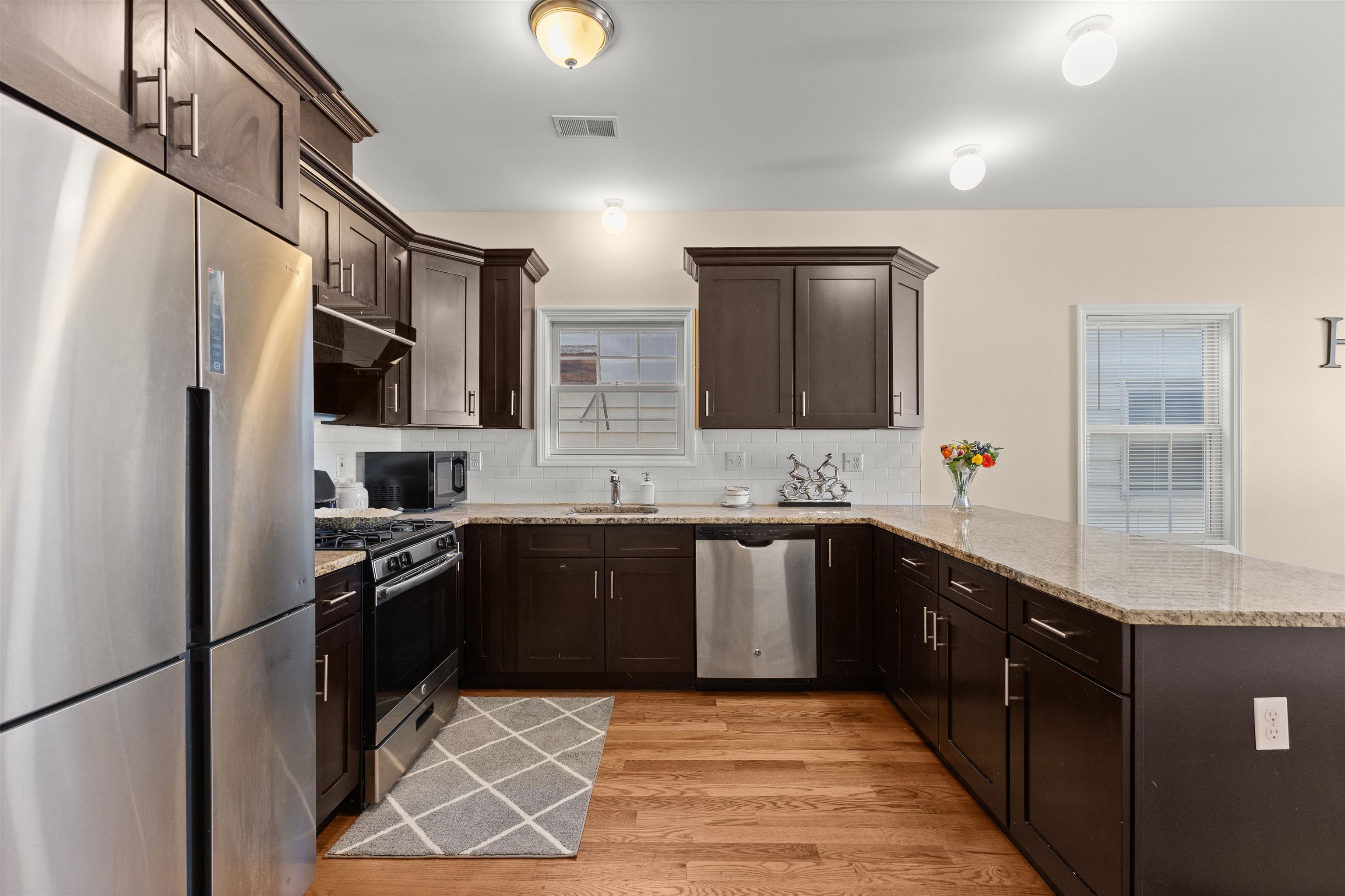 23 Reynolds Avenue, Unit 1 Harrison, NJ 07029 - Photo 2 of 23 a kitchen with stainless steel appliances granite countertop a sink stove and refrigerator