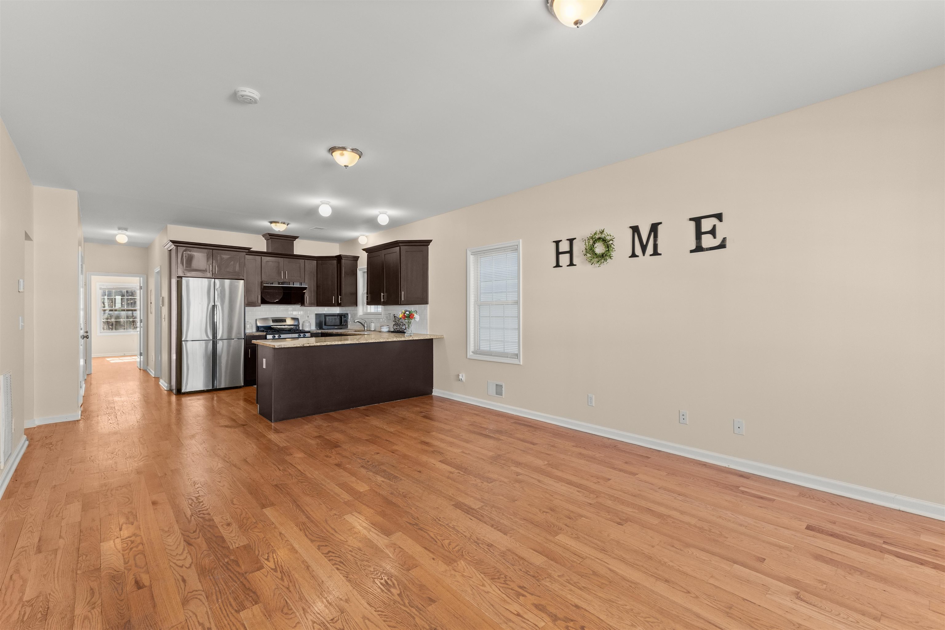 23 Reynolds Avenue, Unit 1 Harrison, NJ 07029 - Photo 5 of 23 a view of kitchen with kitchen island a sink wooden floor and a refrigerator
