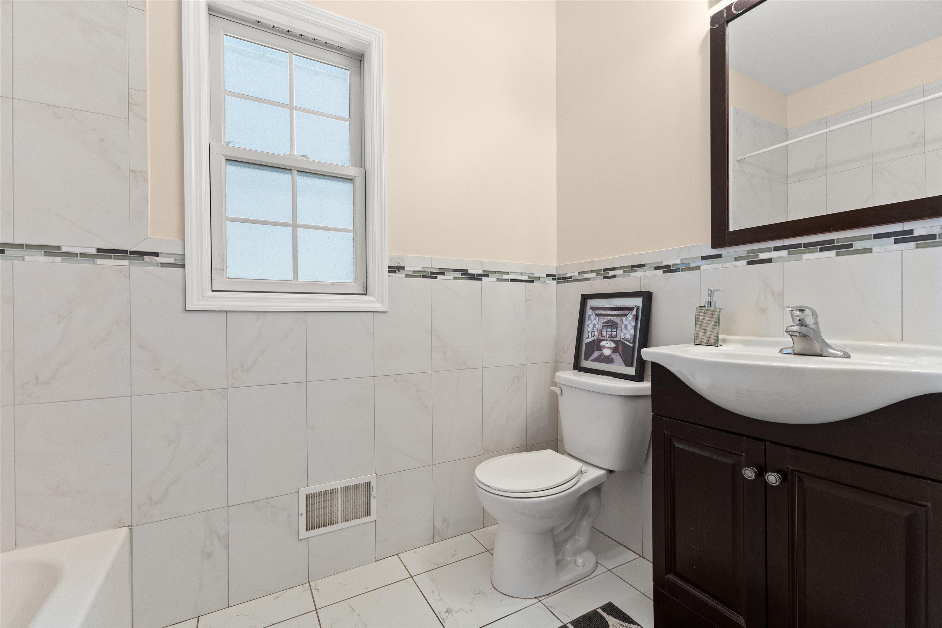 23 Reynolds Avenue, Unit 1 Harrison, NJ 07029 - Photo 8 of 23 a bathroom with a toilet sink and mirror
