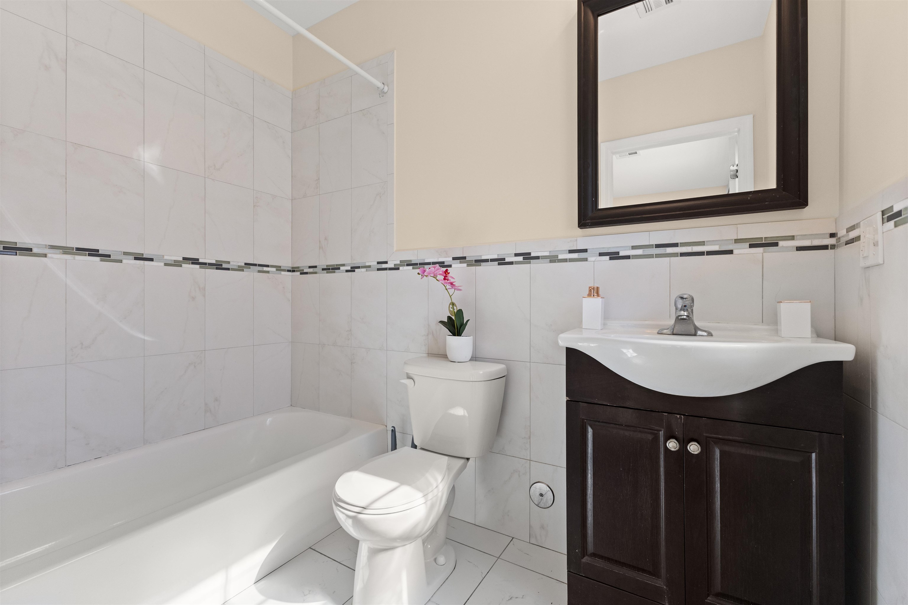 23 Reynolds Avenue, Unit 1 Harrison, NJ 07029 - Photo 9 of 23 a bathroom with a sink a toilet a mirror and bathtub