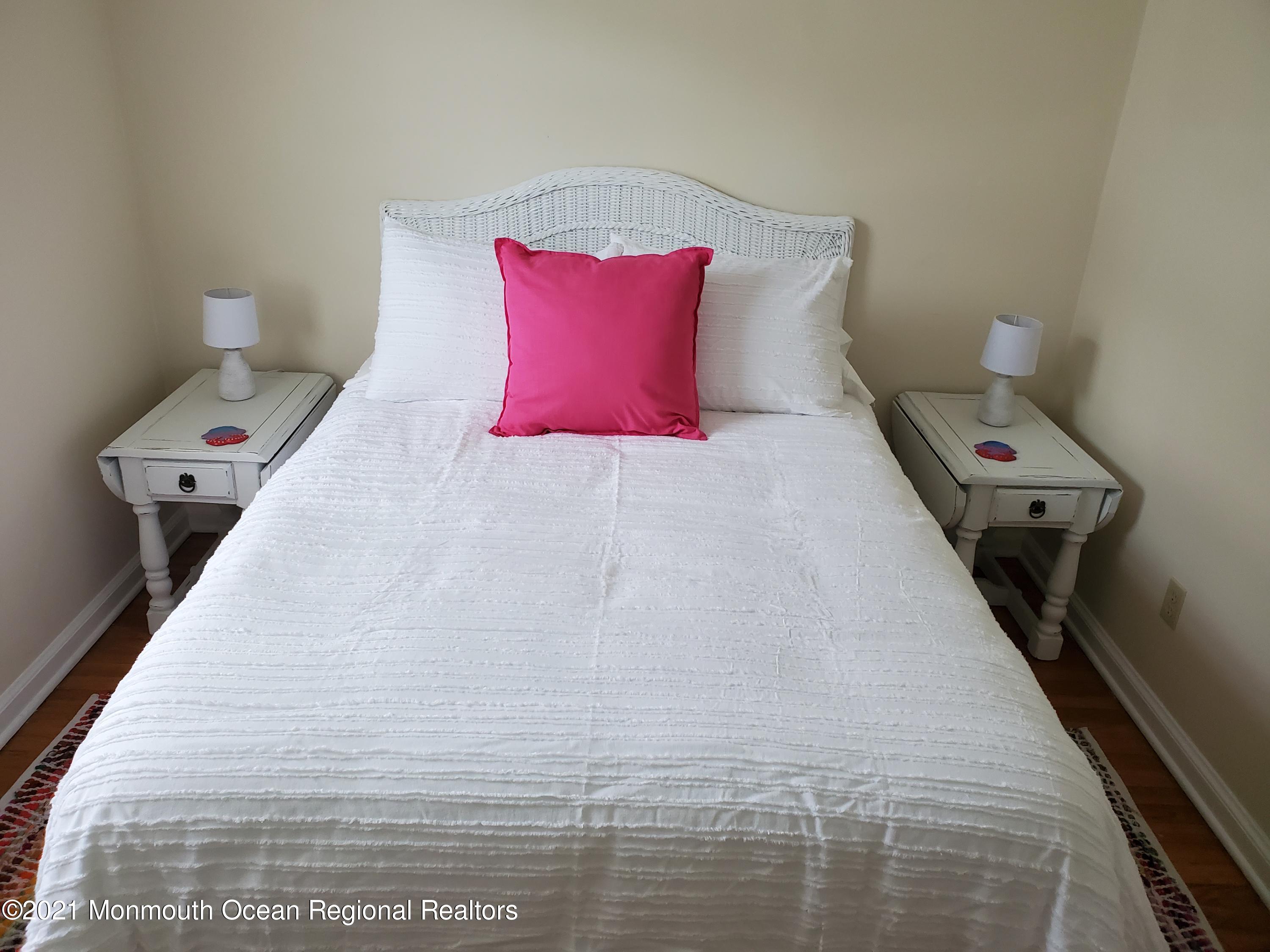 5 Calvert Avenue, Unit B Long Branch, NJ 07740 - Photo 9 of 12 a bed sitting in a bedroom next to a white wall