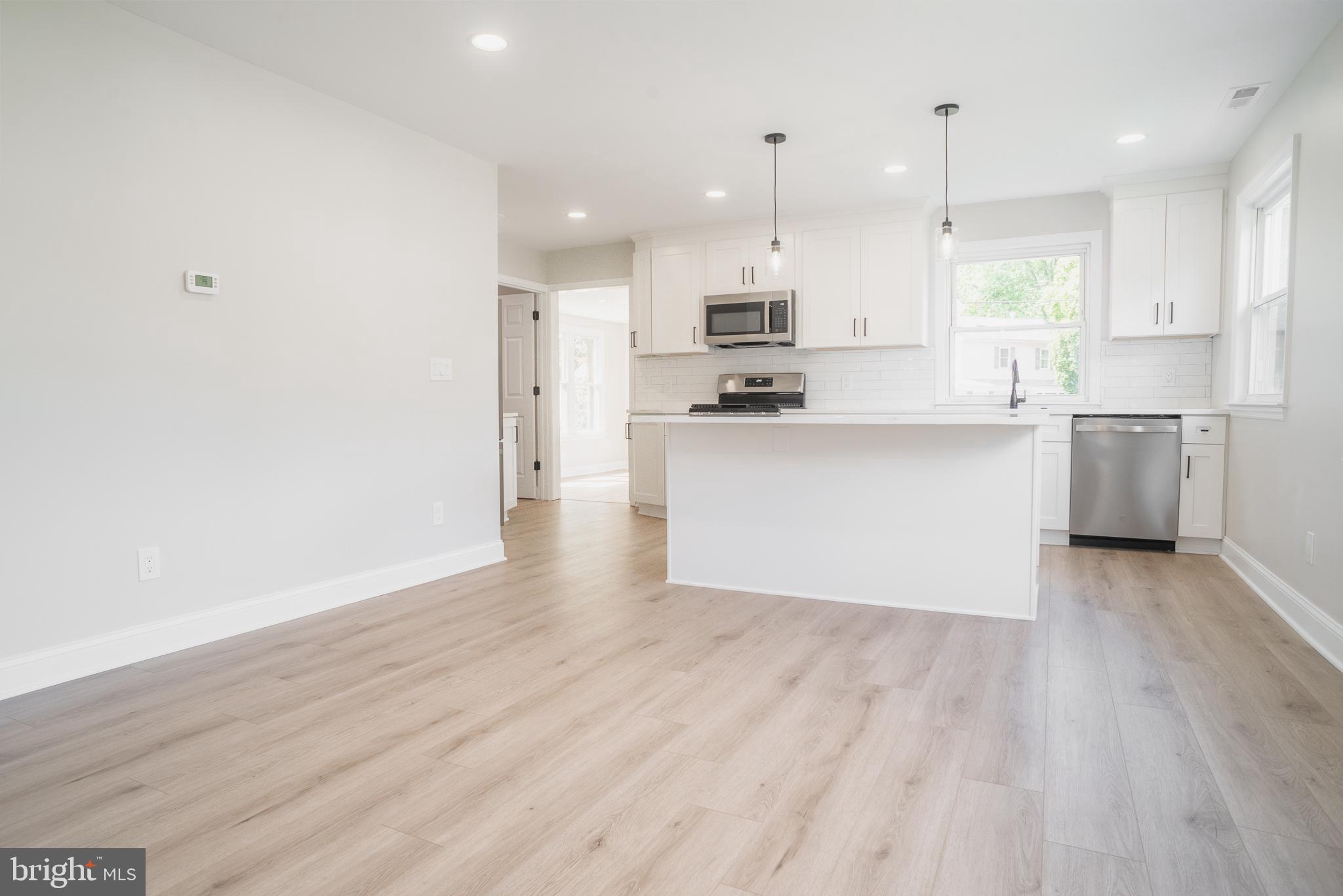 524 West Main Street Maple Shade, NJ 08052 - Photo 7 of 30 a large kitchen with stainless steel appliances granite countertop a stove a sink a refrigerator and white cabinets with wooden floor