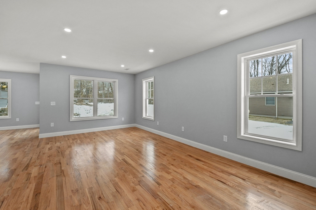 118 Thompson Road, Unit A Webster, MA 01570 - Photo 7 of 39 a view of an empty room with wooden floor and a window