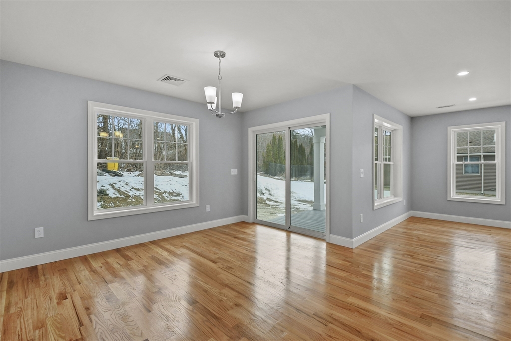118 Thompson Road, Unit A Webster, MA 01570 - Photo 8 of 39 a view of an empty room with wooden floor and a window