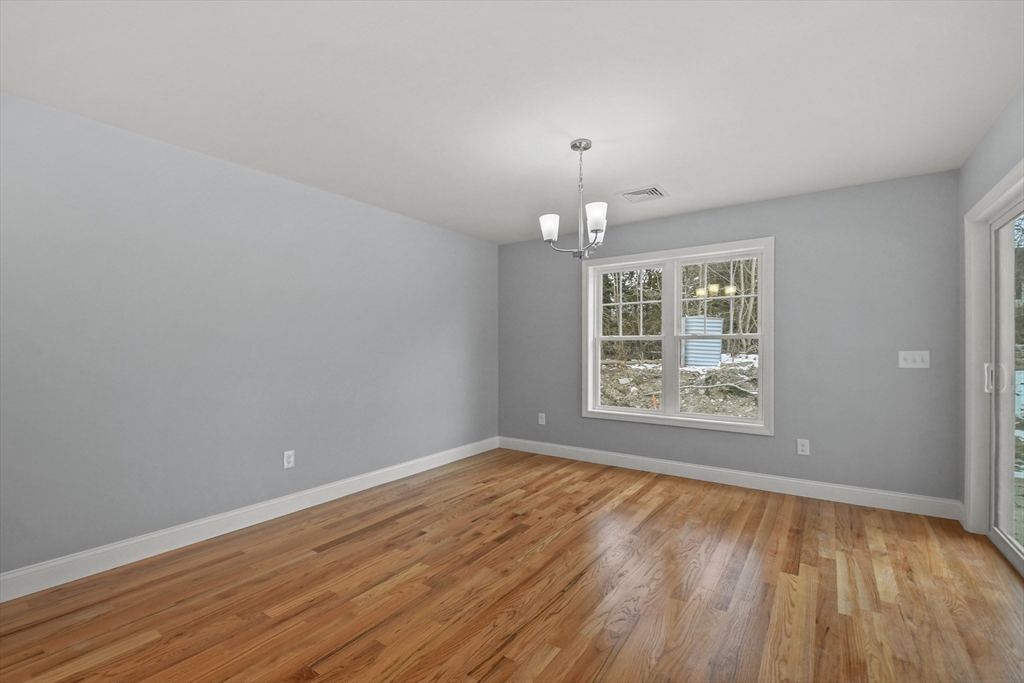 118 Thompson Road, Unit A Webster, MA 01570 - Photo 9 of 39 a view of an empty room with wooden floor and a window