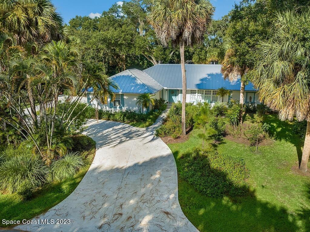 a view of a patio with a table and plants under an umbrella