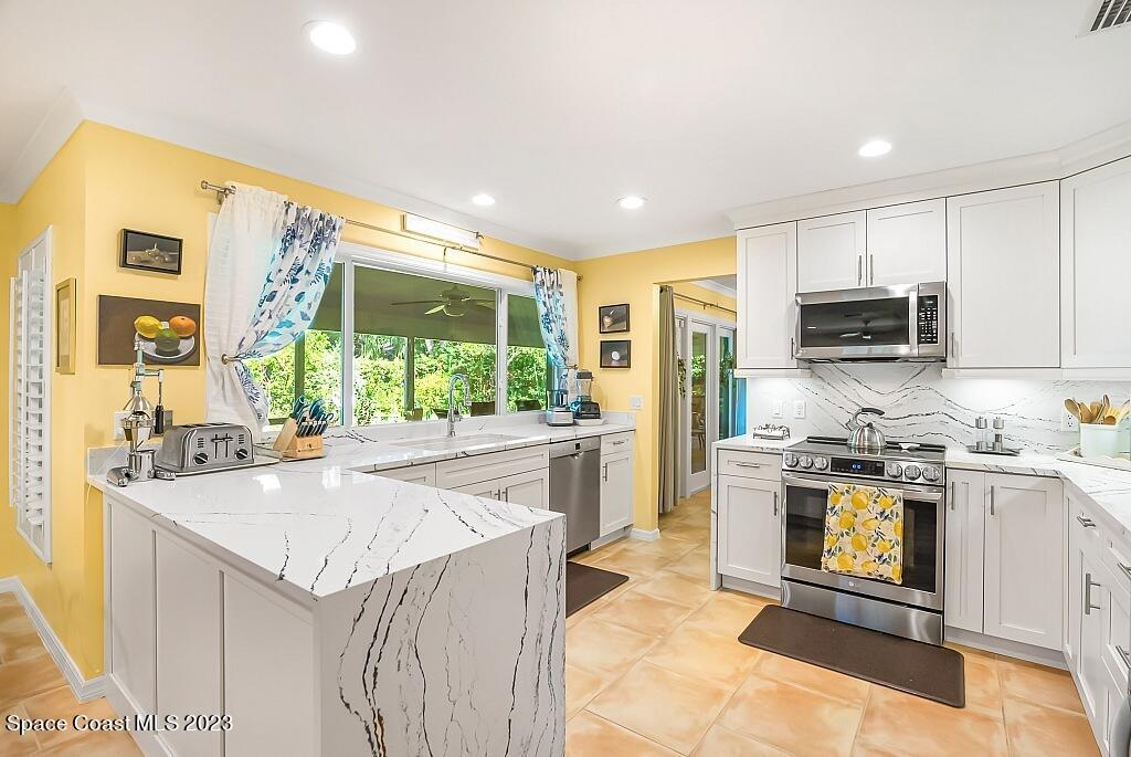 4307 2nd Square Southwest Vero Beach, FL 32968 - Photo 19 of 46 a kitchen with stainless steel appliances granite countertop a stove and a sink