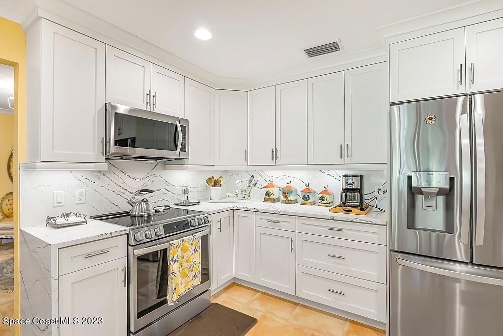 4307 2nd Square Southwest Vero Beach, FL 32968 - Photo 21 of 46 a kitchen with stainless steel appliances a stove microwave and refrigerator