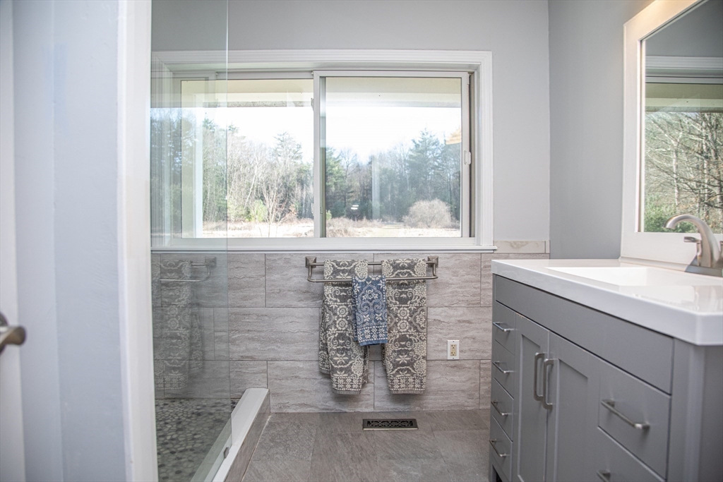 435 Market Hill Road Amherst, MA 01002 - Photo 24 of 42 a bathroom with a granite countertop sink a window and a shower