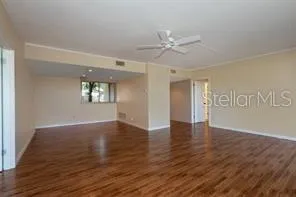 a view of an empty room with a window and wooden floor